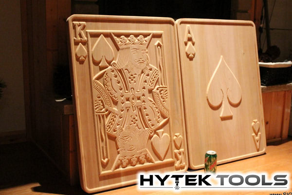 Two large wooden panels depict the King of Hearts and Ace of Spades, each intricately carved using Aspire by Vectric - Version 11.5 software with a CNC router. A small can is in front, and the Hytek Tools logo is featured at the bottom, enhancing this striking display.