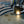 Load image into Gallery viewer, A close-up captures a person wearing gloves using a plasma cutter on metal. Sparks fly from the bright arc, reminiscent of the WeldTEK™ RAYCUS Fiber Laser Welder 1000-3000w by Hytek Tools, as it slices through, revealing grooves from previous cuts.