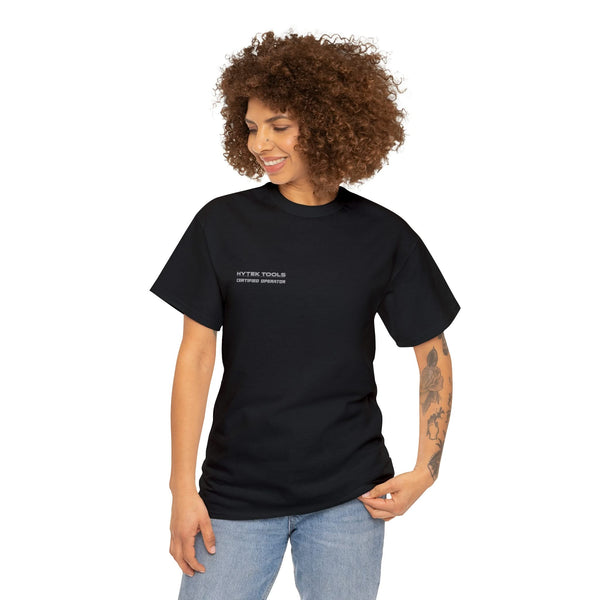 A person with curly hair wears a Printify black unisex heavy cotton tee paired with light blue jeans. The classic fit complements their style as they smile and look down while posing.