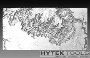A grayscale topographic map of the Grand Canyon shows detailed elevation changes with valleys and ridges, using a light to dark gray gradient. At the bottom, the Hytek Tools - Fiber Laser Sales - USA logo is displayed alongside text about laser cutters, accessories, and CNC routers.