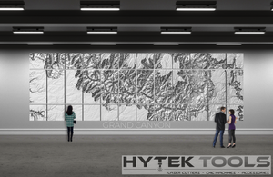 A large wall display showcases the Grand Canyon - STL 3D Terrain Model from Hytek Tools - Fiber Laser Sales - USA, with multiple panels forming a detailed 3D map. Three people observe the work amidst modern industrial flooring and ceiling, with a Hytek Tools logo at the bottom right.