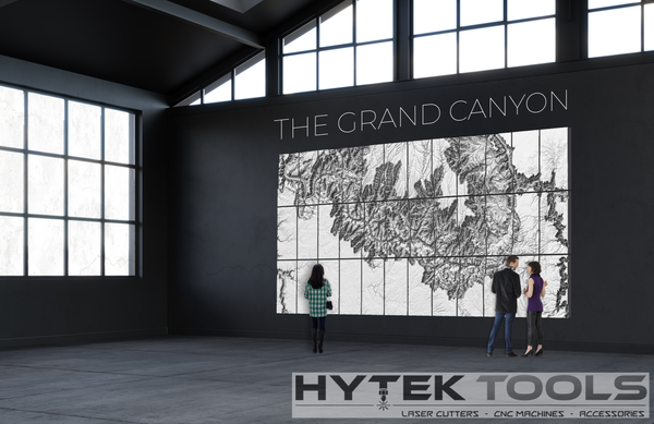 People are viewing a Grand Canyon - STL 3D Terrain Model in a modern, spacious room. A logo at the bottom says Hytek Tools - Fiber Laser Sales - USA, with text mentioning laser cutters, CNC machines, and accessories.