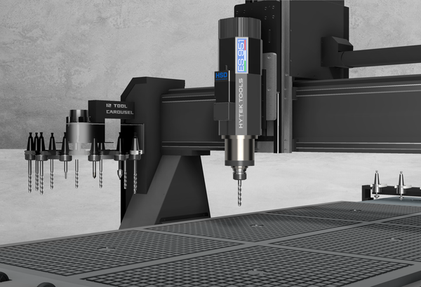 The 2024 ATCTEK™ CNC Industrial Router Machine by Hytek Tools features an automatic tool change carousel with multiple bits, a spindle labeled HSD and HYTEK TOOLS, a grid-patterned bed, and is set against a plain wall.